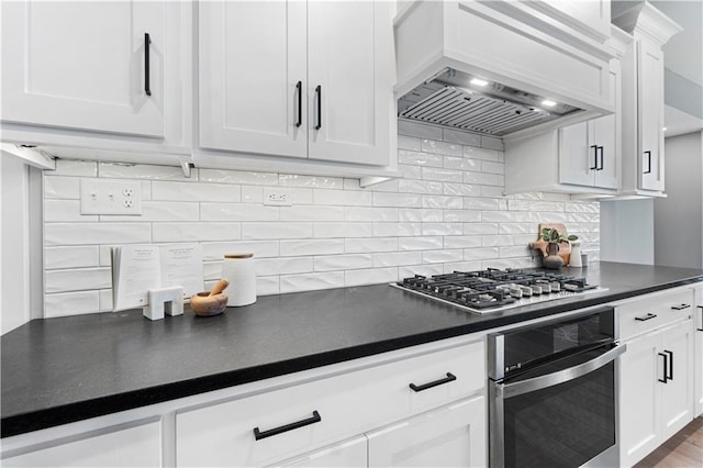 15837 El Monte St, Overland Park, KS 66224 - kitchen featuring stainless steel appliances, custom range hood, dark countertops, white cabinetry, and tasteful backsplash