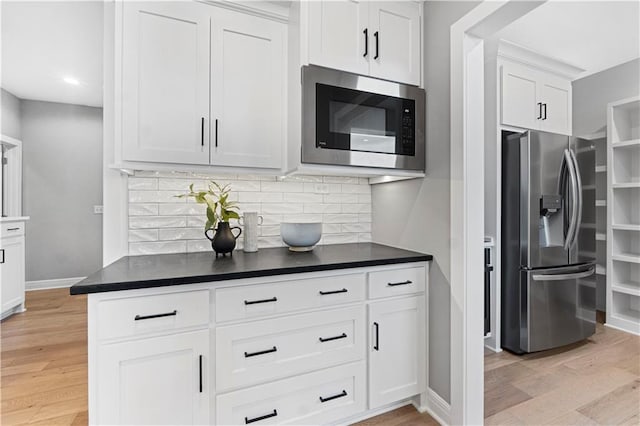 15837 El Monte St, Overland Park, KS 66224 - kitchen with appliances with stainless steel finishes, light wood-type flooring, decorative backsplash, white cabinetry, and recessed lighting