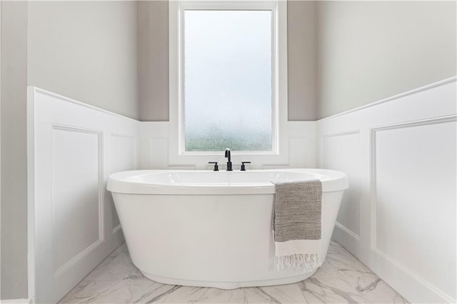 15837 El Monte St, Overland Park, KS 66224 - bathroom with marble finish flooring, wainscoting, a decorative wall, and a freestanding bath