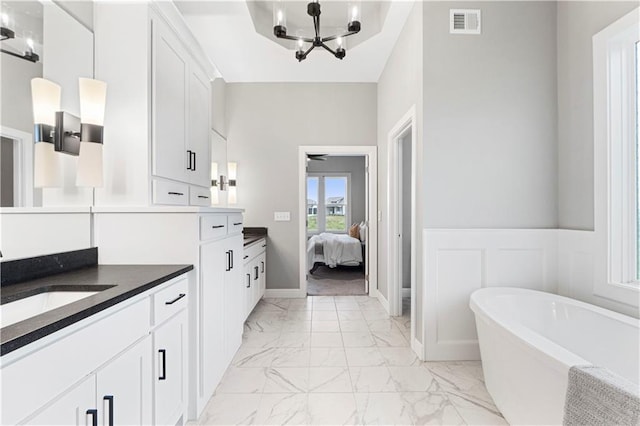 15837 El Monte St, Overland Park, KS 66224 - ensuite bathroom featuring marble look tiles, a soaking tub, vanity, and a chandelier