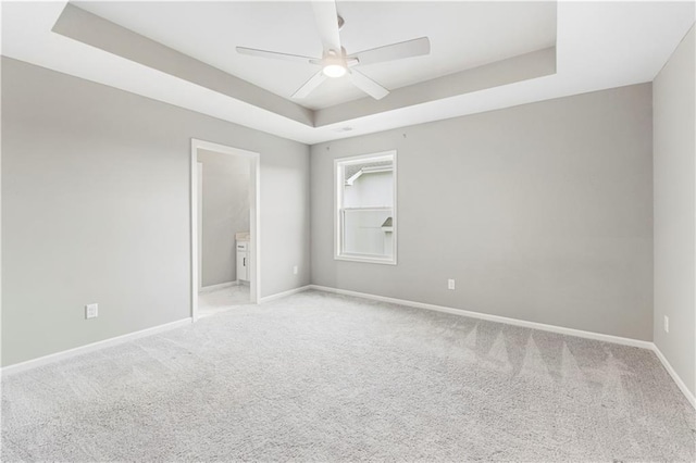 15837 El Monte St, Overland Park, KS 66224 - unfurnished bedroom featuring a tray ceiling, light carpet, ensuite bath, and a ceiling fan
