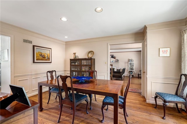 6451 Sagamore Rd, Mission Hills, KS 66208 - dining area with a decorative wall, ornamental molding, light wood-style flooring, and recessed lighting