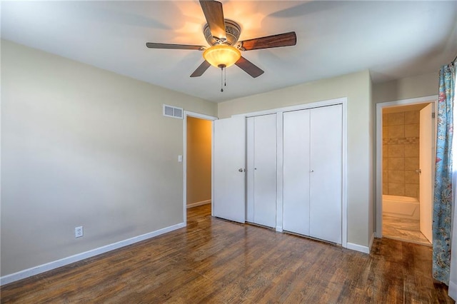 16100 E Elm St, Independence, MO 64050 - unfurnished bedroom featuring multiple closets, wood finished floors, and a ceiling fan