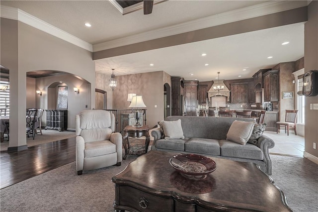 1217 Kingsland Cir, Raymore, MO 64083 - carpeted living area featuring arched walkways, recessed lighting, and crown molding