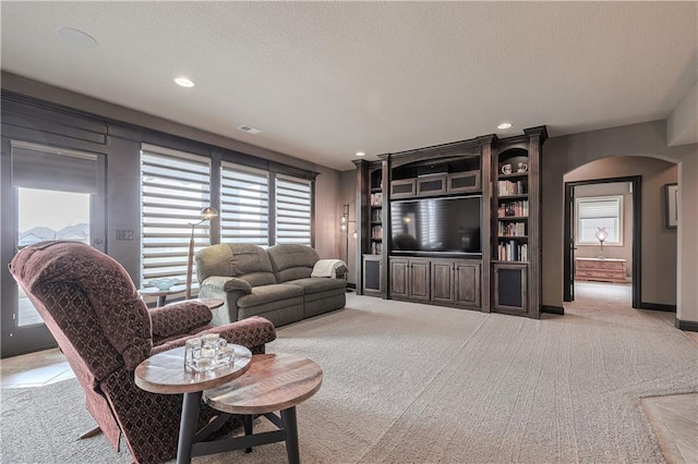 1217 Kingsland Cir, Raymore, MO 64083 - living area featuring arched walkways, carpet, recessed lighting, and a textured ceiling