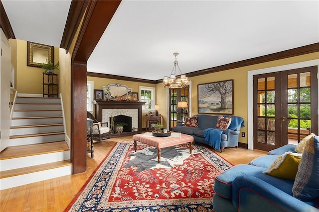 533 S Water St, Olathe, KS 66061 - living room with stairway, a chandelier, french doors, crown molding, and a fireplace