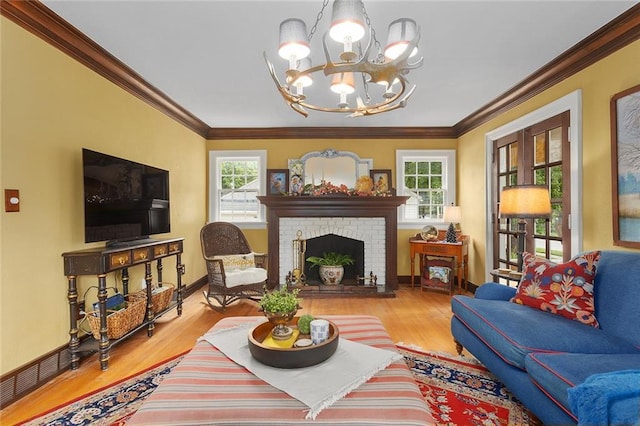 533 S Water St, Olathe, KS 66061 - living area with a chandelier, wood finished floors, ornamental molding, and a brick fireplace