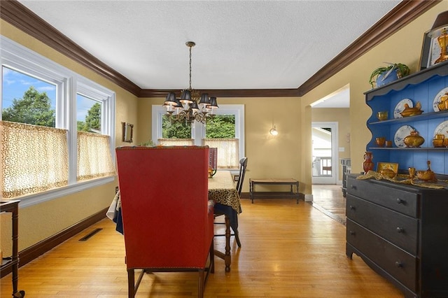533 S Water St, Olathe, KS 66061 - dining area with a chandelier, crown molding, healthy amount of natural light, light wood-style floors, and a textured ceiling