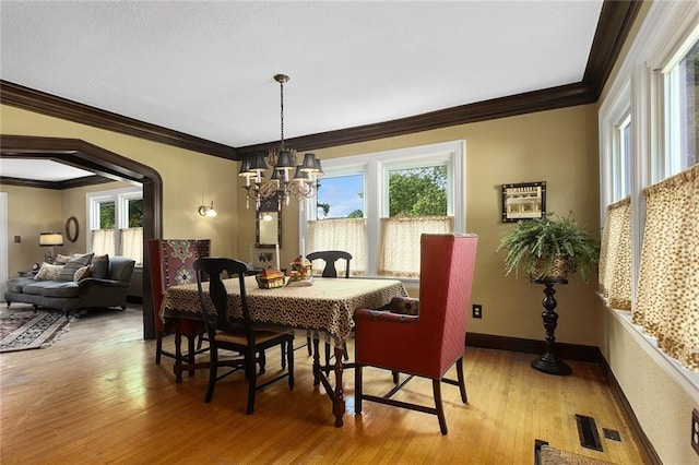 533 S Water St, Olathe, KS 66061 - dining space featuring plenty of natural light, a chandelier, crown molding, and light wood-type flooring