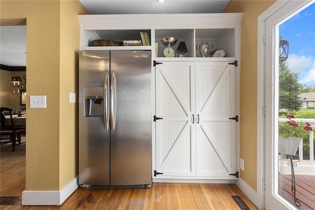 533 S Water St, Olathe, KS 66061 - kitchen featuring stainless steel refrigerator with ice dispenser, light wood-style flooring, open shelves, and white cabinetry