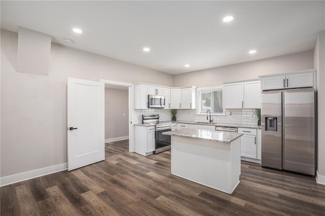 1116 Splitlog Ave, Kansas City, KS 66102 - kitchen featuring stainless steel appliances, white cabinetry, backsplash, a center island, and dark wood-style flooring