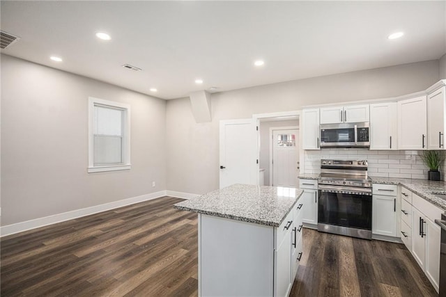 1116 Splitlog Ave, Kansas City, KS 66102 - kitchen with appliances with stainless steel finishes, a center island, tasteful backsplash, light stone countertops, and recessed lighting