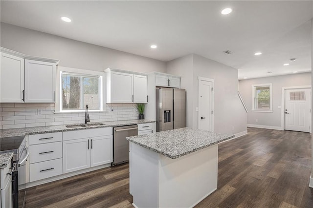 1116 Splitlog Ave, Kansas City, KS 66102 - kitchen featuring appliances with stainless steel finishes, white cabinetry, tasteful backsplash, dark wood-type flooring, and recessed lighting