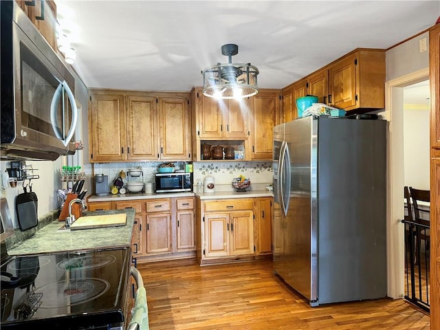 1607 S St, Lexington, MO 64067 - kitchen with stainless steel appliances, light countertops, light wood-style flooring, and tasteful backsplash