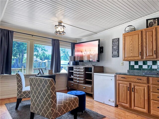 1607 S St, Lexington, MO 64067 - kitchen featuring fridge, light wood-style floors, brown cabinets, dark countertops, and wood ceiling