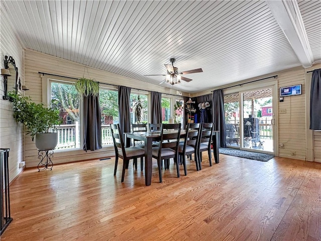 1607 S St, Lexington, MO 64067 - dining area with a ceiling fan, wood walls, light wood-type flooring, and healthy amount of natural light