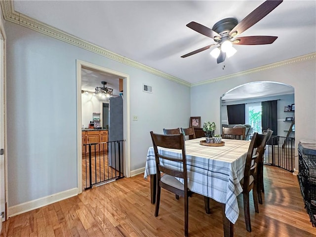 1607 S St, Lexington, MO 64067 - dining area with arched walkways, ceiling fan, light wood-type flooring, and ornamental molding