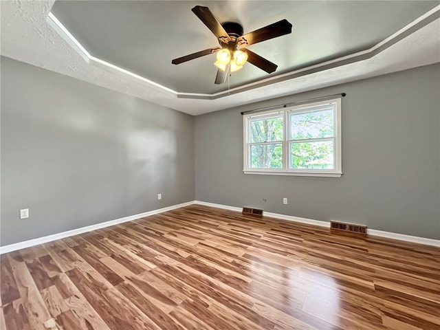 118 Fern St, Lansing, KS 66043 - unfurnished room with a tray ceiling, wood finished floors, and a ceiling fan