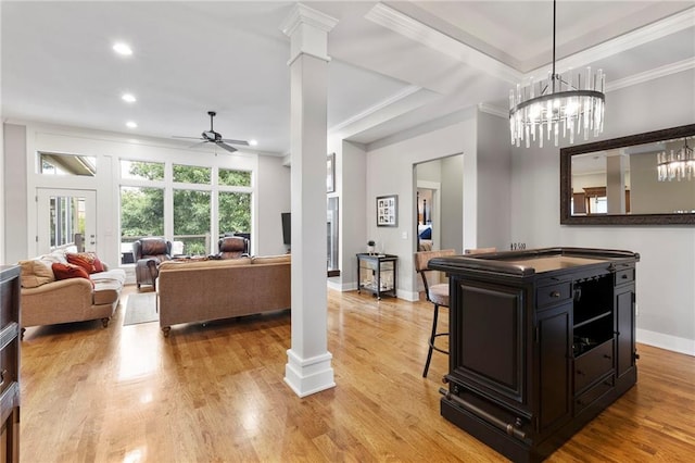 11717 S Barth Rd, Olathe, KS 66061 - kitchen featuring ornamental molding, decorative columns, a ceiling fan, a kitchen bar, and dark cabinets