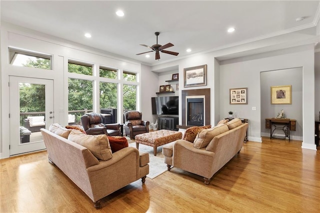 11717 S Barth Rd, Olathe, KS 66061 - living area with crown molding, a ceiling fan, light wood-type flooring, recessed lighting, and a glass covered fireplace