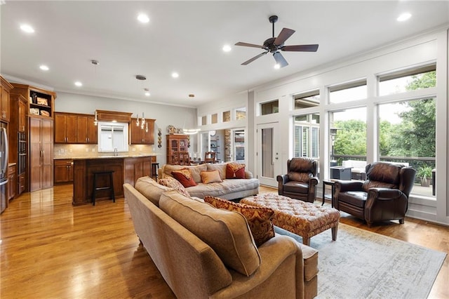 11717 S Barth Rd, Olathe, KS 66061 - living area featuring crown molding, healthy amount of natural light, recessed lighting, light wood-style flooring, and ceiling fan