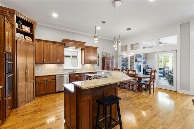 11717 S Barth Rd, Olathe, KS 66061 - kitchen with stainless steel appliances, a breakfast bar area, tasteful backsplash, a kitchen island, and light wood finished floors