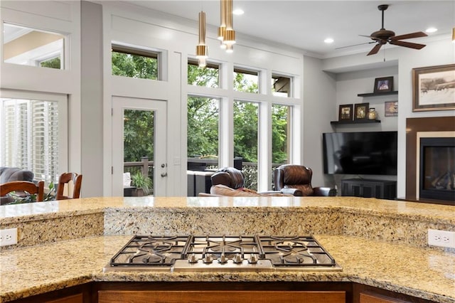 11717 S Barth Rd, Olathe, KS 66061 - kitchen with stainless steel gas stovetop, open floor plan, ornamental molding, light stone countertops, and ceiling fan