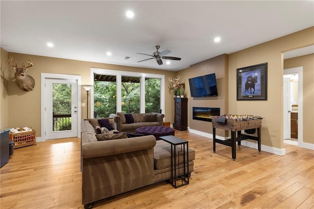 11717 S Barth Rd, Olathe, KS 66061 - living area with light wood-style flooring, ceiling fan, a glass covered fireplace, and recessed lighting