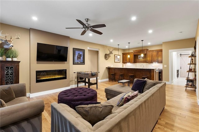 11717 S Barth Rd, Olathe, KS 66061 - living room featuring a glass covered fireplace, a ceiling fan, recessed lighting, and light wood-style floors
