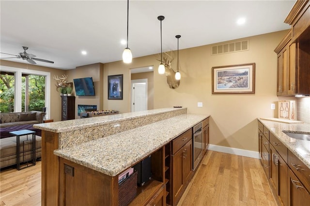 11717 S Barth Rd, Olathe, KS 66061 - kitchen with a peninsula, light wood-style flooring, ceiling fan, wall oven, and recessed lighting
