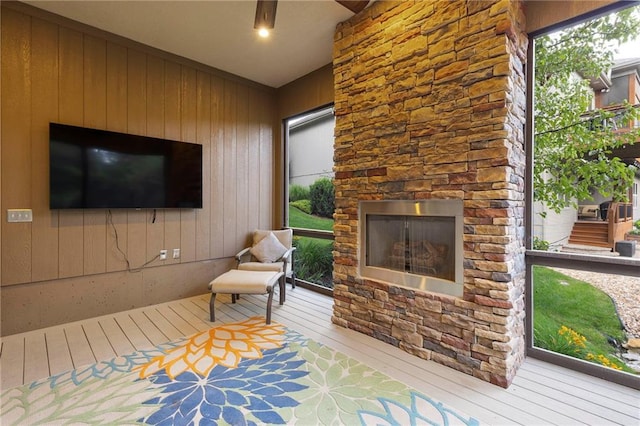 11717 S Barth Rd, Olathe, KS 66061 - living area with an outdoor stone fireplace, hardwood / wood-style flooring, wood walls, and healthy amount of natural light