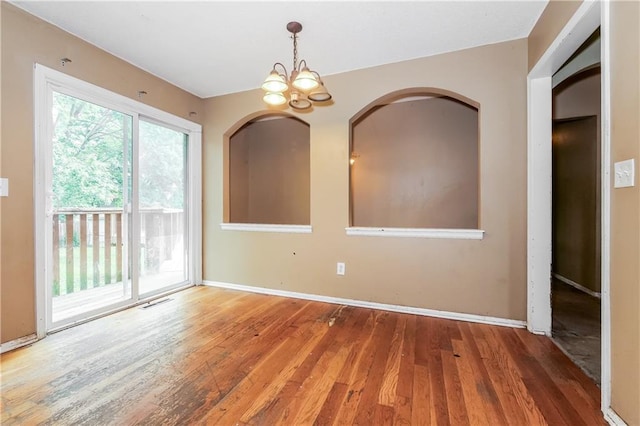 20408 E 15th Ter, Independence, MO 64056 - spare room with wood-type flooring, a chandelier, and arched walkways