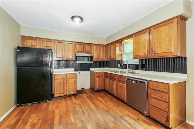 20408 E 15th Ter, Independence, MO 64056 - kitchen with appliances with stainless steel finishes, light wood-type flooring, brown cabinets, and light countertops