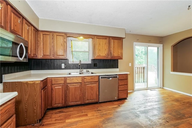 20408 E 15th Ter, Independence, MO 64056 - kitchen with stainless steel appliances, brown cabinets, plenty of natural light, and light wood-type flooring