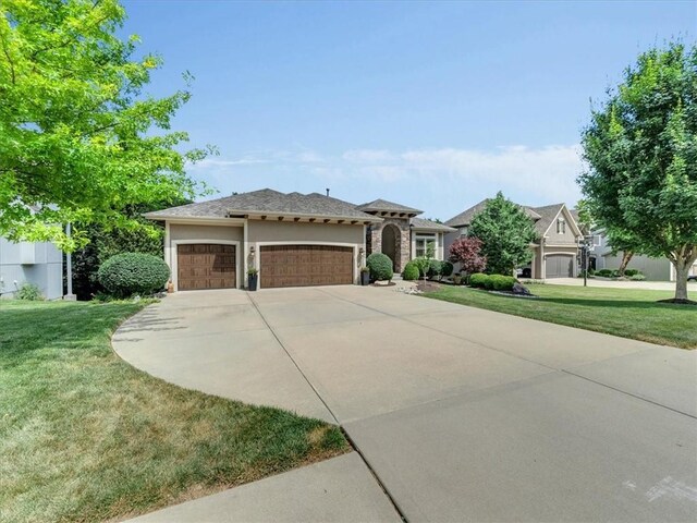 11599 S Carbondale St, Olathe, KS 66061 - view of front of property featuring an attached garage, a front lawn, driveway, and stucco siding