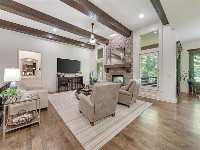 11599 S Carbondale St, Olathe, KS 66061 - living area with a ceiling fan, wood finished floors, a stone fireplace, beam ceiling, and recessed lighting