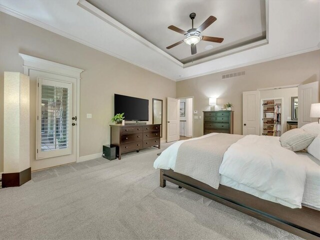 11599 S Carbondale St, Olathe, KS 66061 - carpeted bedroom featuring a raised ceiling, ornamental molding, a ceiling fan, access to exterior, and a walk in closet