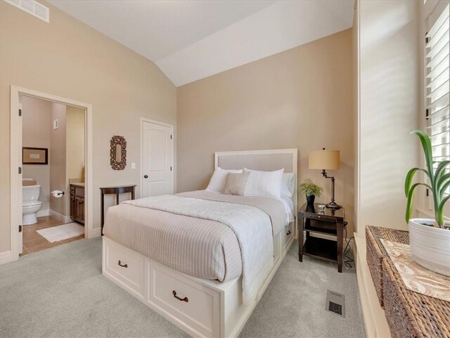11599 S Carbondale St, Olathe, KS 66061 - bedroom featuring light carpet, vaulted ceiling, and ensuite bath