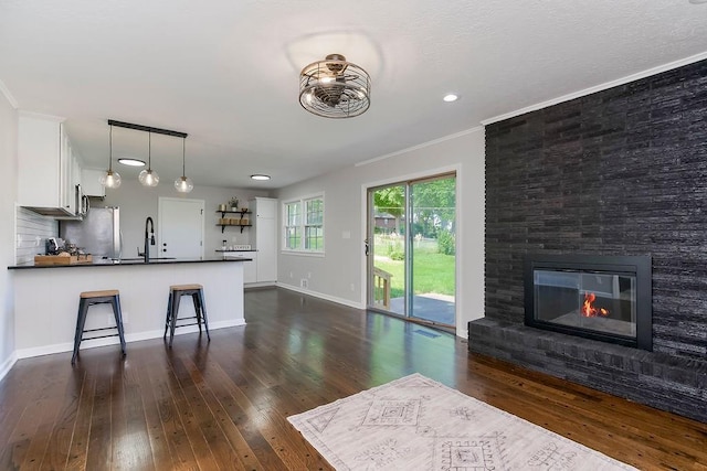 4309 S Huntington Way, Independence, MO 64055 - kitchen featuring dark countertops, dark wood-style flooring, white cabinetry, a peninsula, and open floor plan