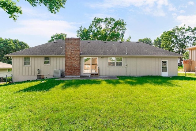 4309 S Huntington Way, Independence, MO 64055 - rear view of property with board and batten siding, a chimney, a yard, and a patio area