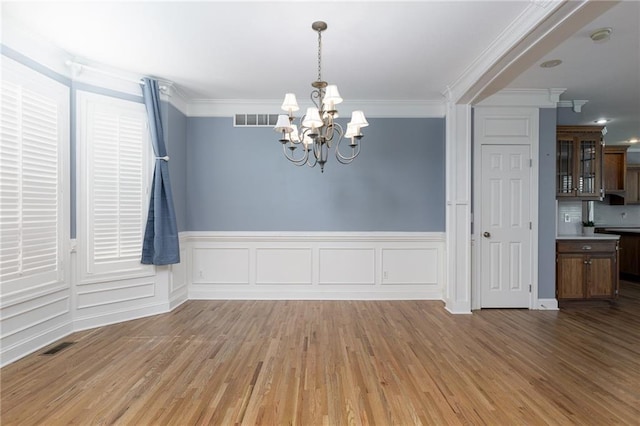 8620 N Eastern Ave, Kansas City, MO 64157 - unfurnished dining area with a chandelier, light wood-type flooring, ornamental molding, and a wainscoted wall
