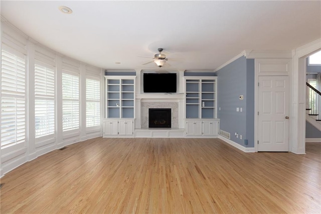 8620 N Eastern Ave, Kansas City, MO 64157 - unfurnished living room featuring a ceiling fan, light wood finished floors, a fireplace with raised hearth, stairway, and crown molding