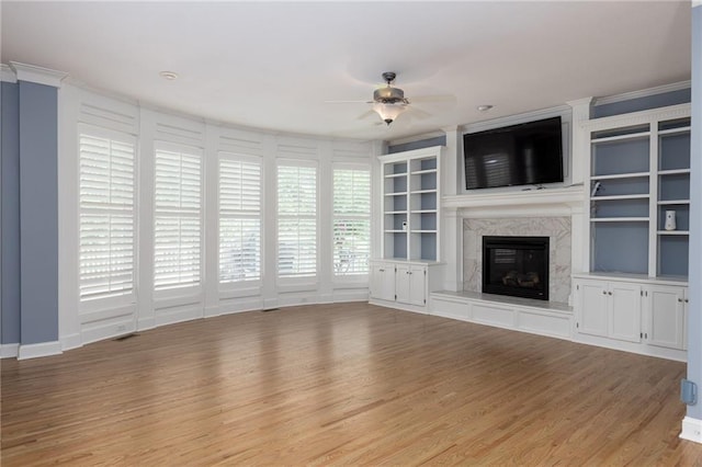 8620 N Eastern Ave, Kansas City, MO 64157 - unfurnished living room featuring ceiling fan, wood finished floors, a high end fireplace, and crown molding