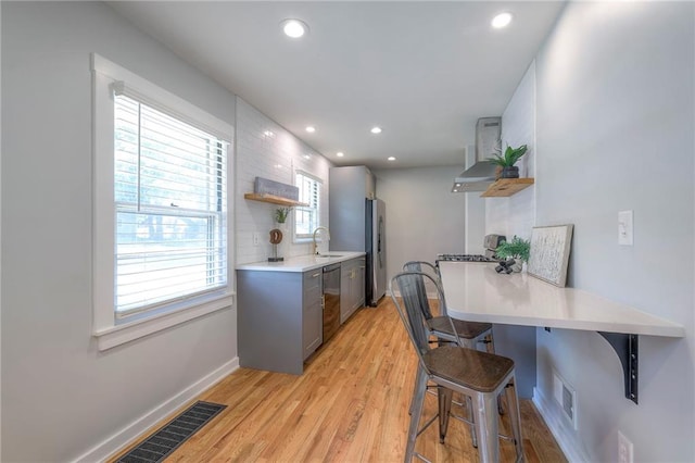 11417 Applewood Dr, Kansas City, MO 64134 - kitchen featuring open shelves, stainless steel appliances, wall chimney exhaust hood, recessed lighting, and light wood-style flooring