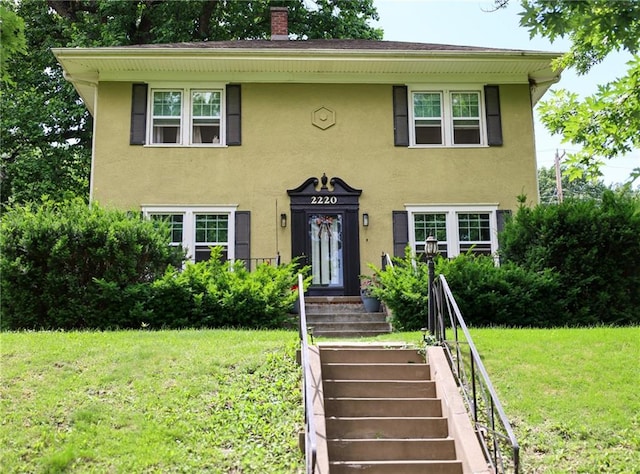 2220 Eugene Field Ave, Saint Joseph, MO 64505 - view of front of property with stucco siding, a front yard, and a chimney