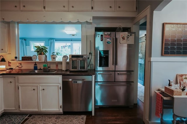 2220 Eugene Field Ave, Saint Joseph, MO 64505 - kitchen with stainless steel appliances, dark countertops, and dark wood-style floors