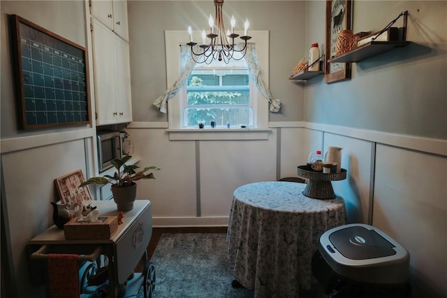 2220 Eugene Field Ave, Saint Joseph, MO 64505 - bathroom with a chandelier, a decorative wall, a wainscoted wall, and wood finished floors