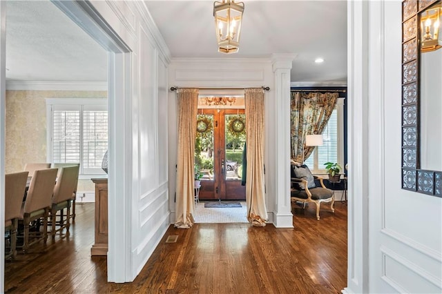 3215 Windsor Ave, Kansas City, MO 64123 - foyer entrance featuring ornate columns, dark wood finished floors, plenty of natural light, crown molding, and french doors