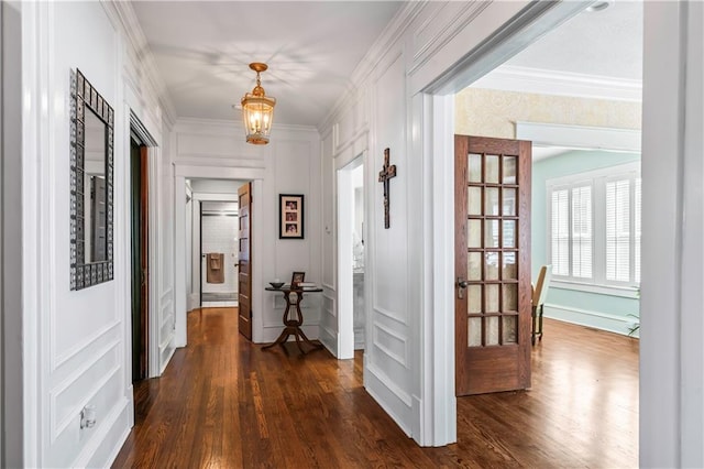 3215 Windsor Ave, Kansas City, MO 64123 - hallway featuring a decorative wall, dark wood-style floors, a chandelier, and crown molding