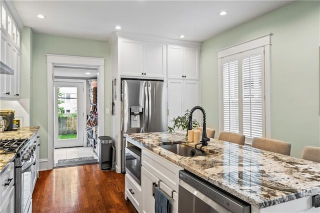 3215 Windsor Ave, Kansas City, MO 64123 - kitchen with appliances with stainless steel finishes, light stone countertops, white cabinets, recessed lighting, and dark wood-type flooring